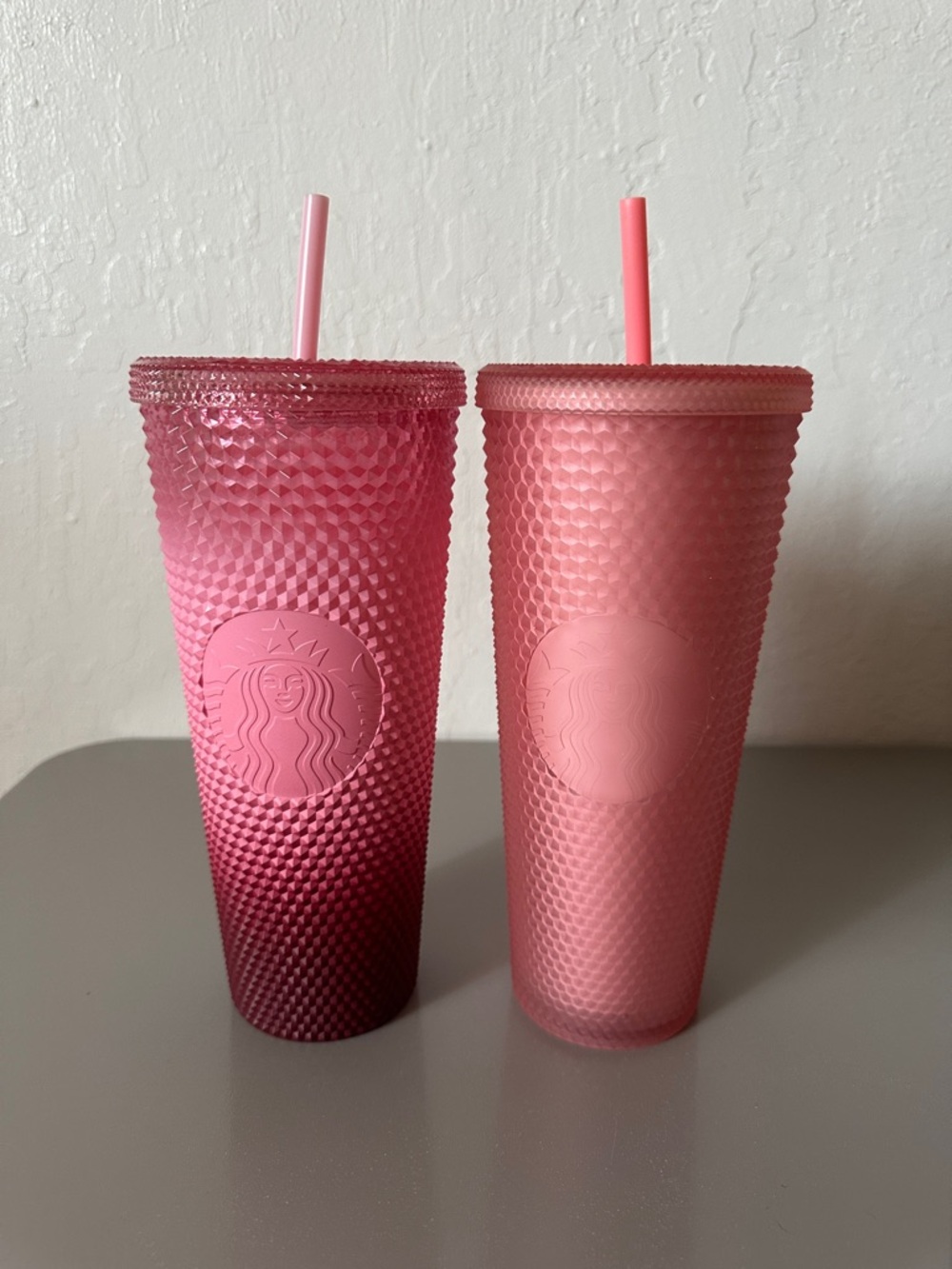 Two pink Starbucks tumblers